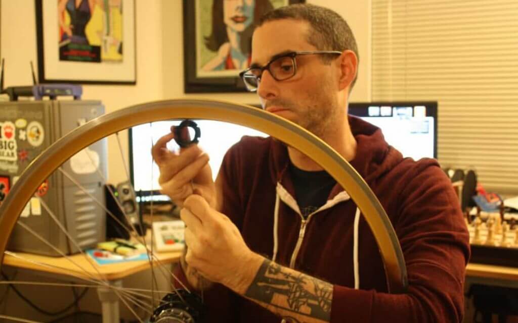 Josh_Sawyer_removing_spokes_from_a_bicycle_wheel.
